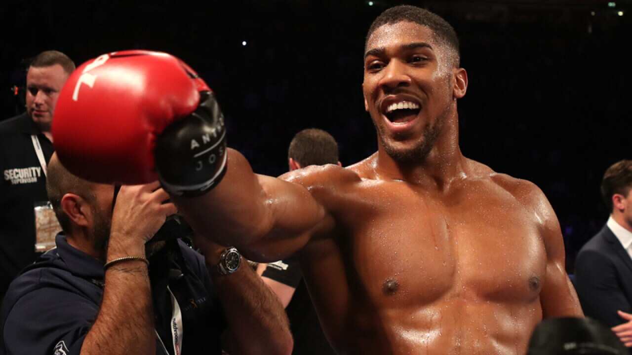 Anthony Joshua celebrates after beating Eric Molina