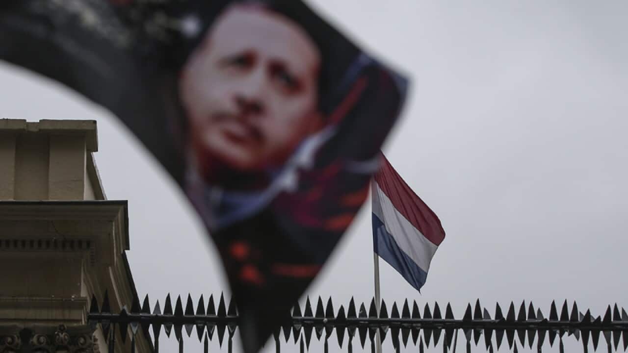 A banner with the Turkish President is seen with a Dutch flag