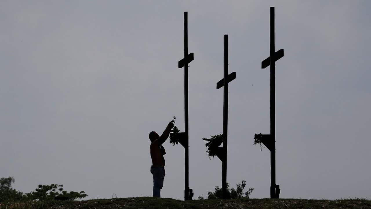 A Filipino penitent places his crown of thorns during Good Friday rituals to atone for sins.