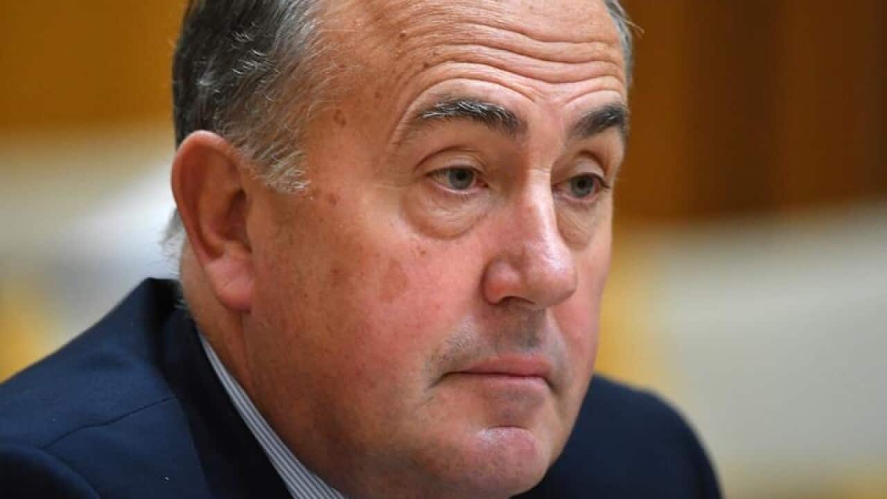 John Fraser looks on.