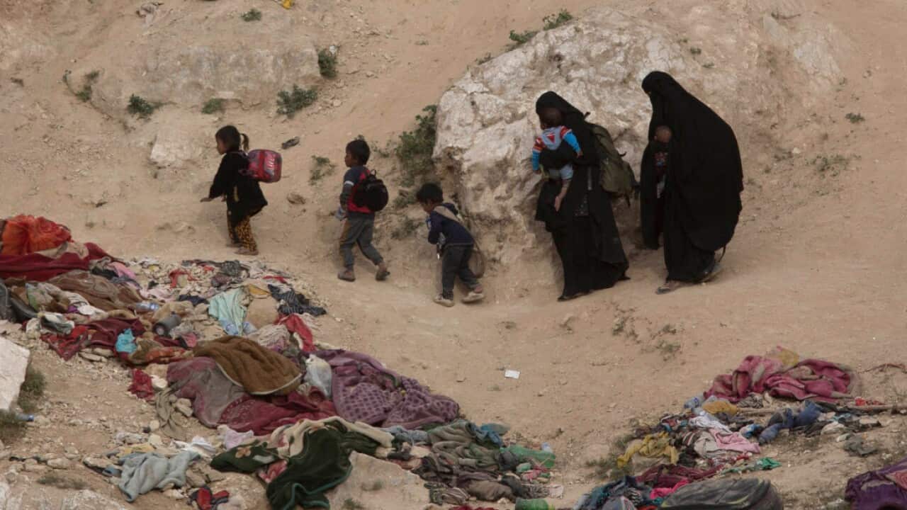 In this March 14, 2019, file photo, women and their children who left the besieged Islamic State-held village of Baghouz, Syria, scramble over a rocky hillside to be checked by U.S-backed Syrian Democratic Forces (AAP)