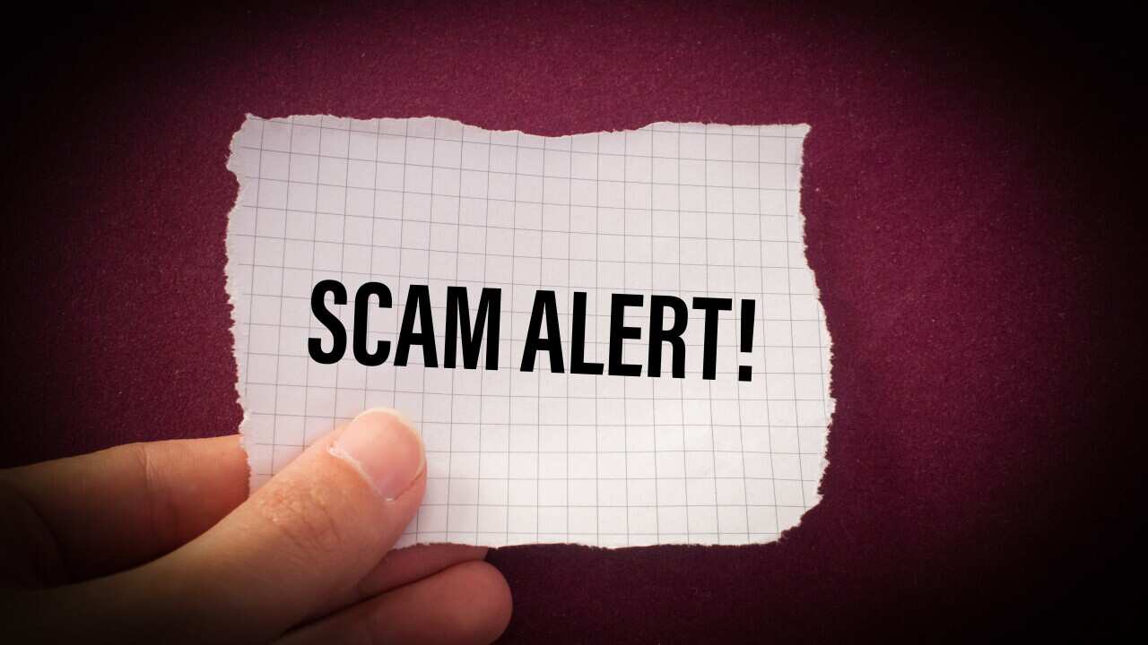 Scam Alert! word written on torn paper.