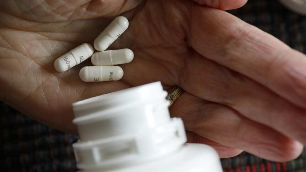 hand holding pills from bottle