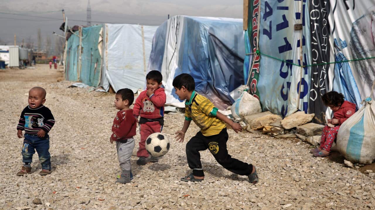 Syrian refugee children play outside their family tents to a camp in the town of Saadnayel, in the Bekaa valley, Lebanon