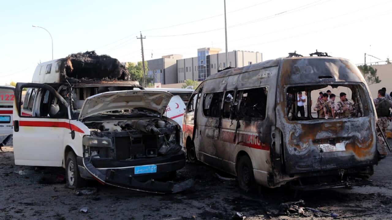 The wreckage of burnt ambulances at the site of a car bomb explosion