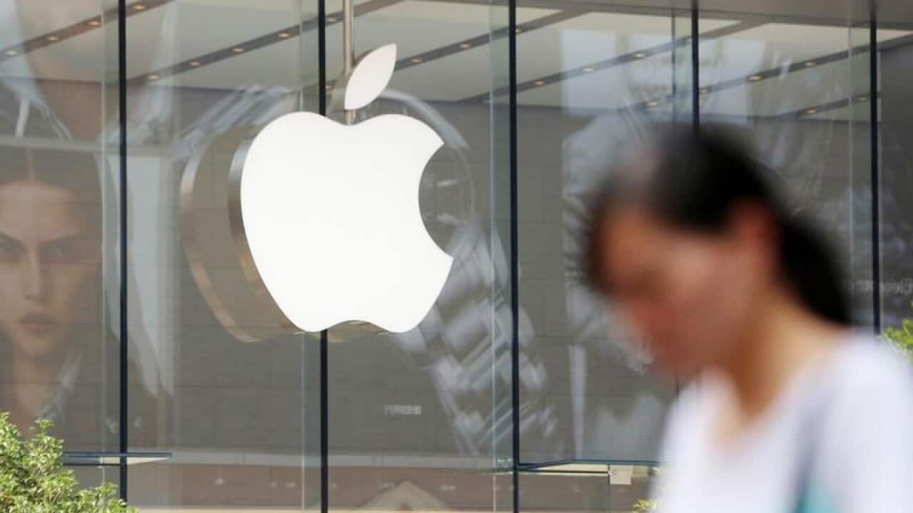 A pedestrian walks past the Apple Store in Shanghai