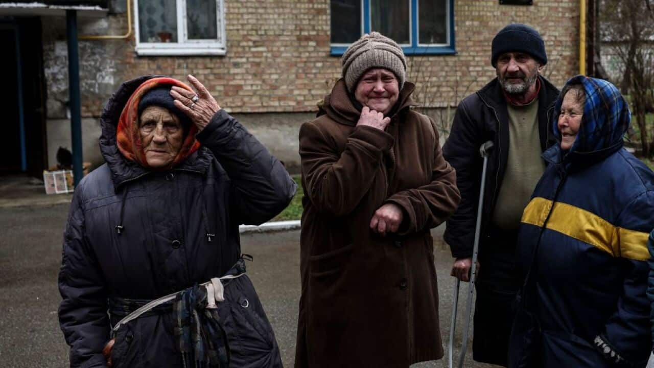 Women cry outside their houses in Bucha, northwest of Kyiv, where town's mayor said 300 people had been buried in a mass grave and that the town is littered with corpses.