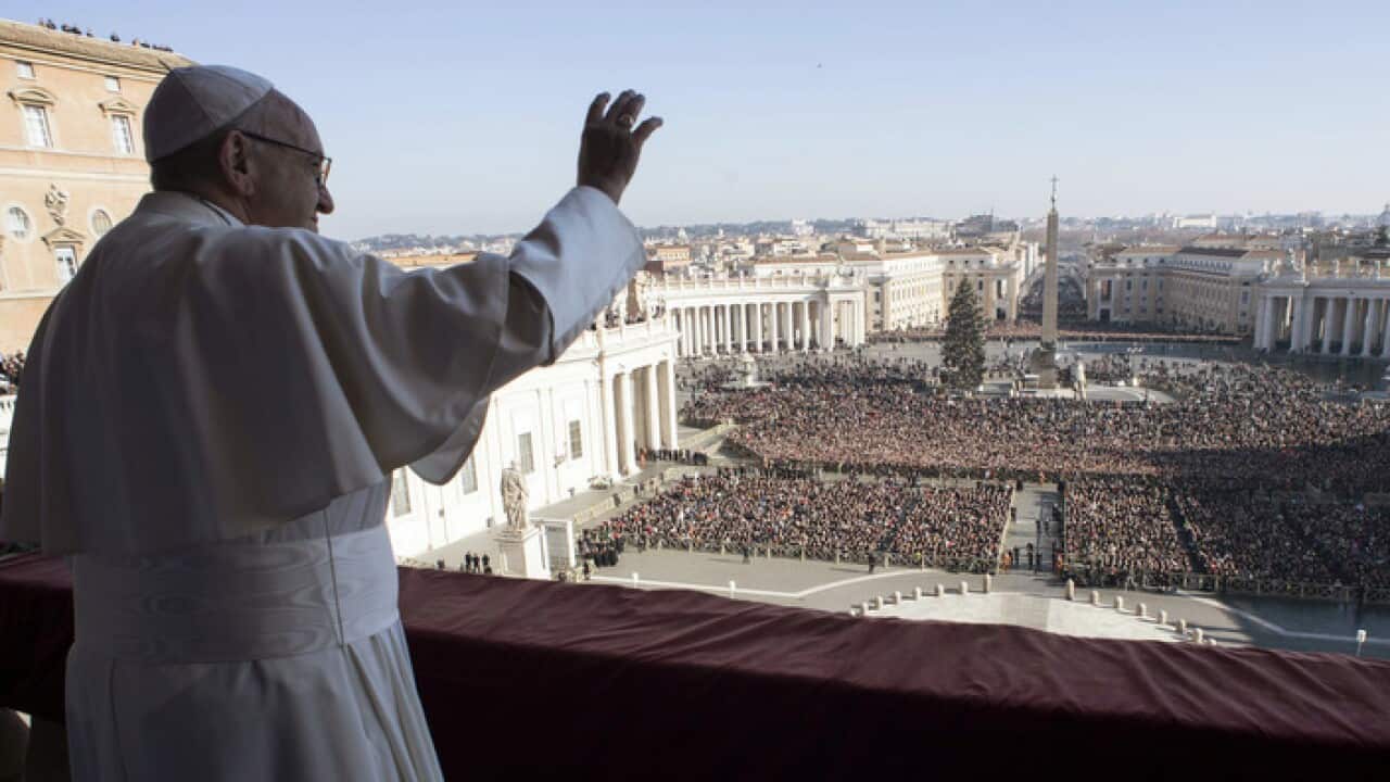 Pope Francis waves to the faithful during the traditional Urbi et Orbi Christmas Day message