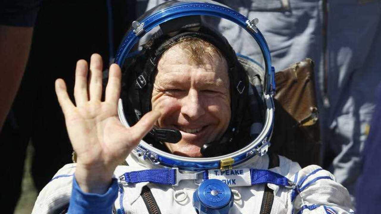 Britain's Tim Peake waves after landing near the town of Dzhezkazgan, Kazakhstan
