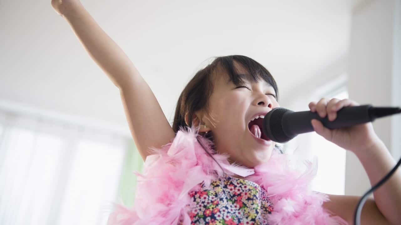 Filipino girl singing karaoke in living room