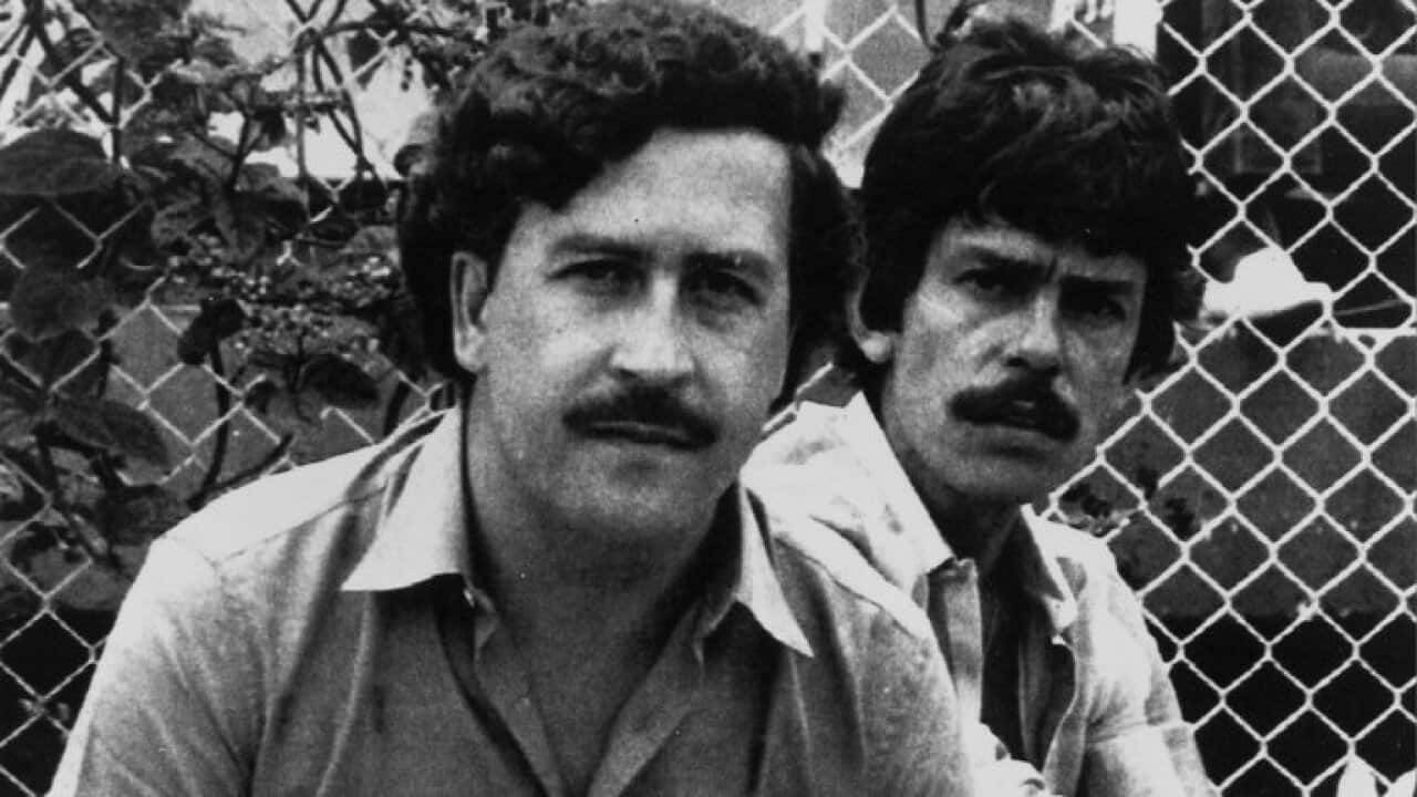Pablo Escobar, left, 41-year-old billionaire leader of the Medellin drug cartel, poses at a soccer game in Medellin, Colombia, in 1983. At right is an unidentified bodyguard. (AP Photo)