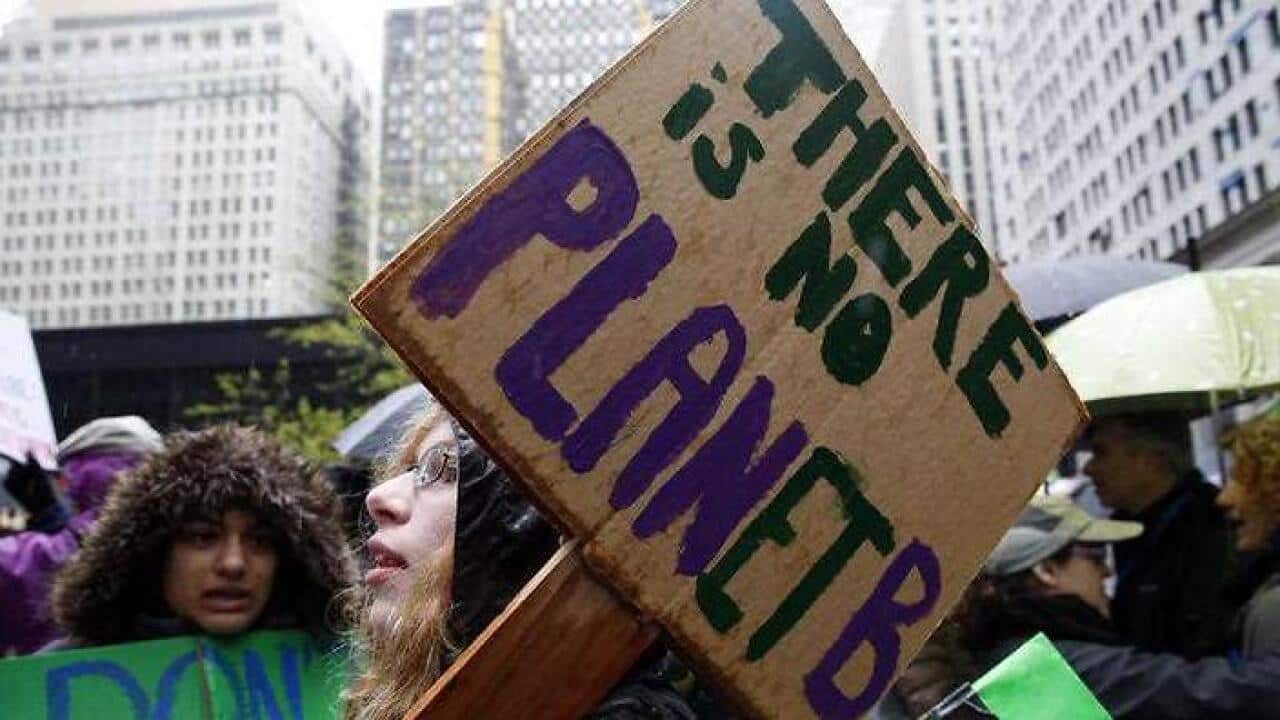 Demonstrators hold signs during a "100 Days of Failure" protest and march in Chicago. (AAP)