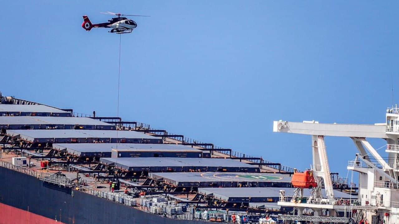 A helicopter hovers over the vessel MV Wakashio that ran aground and caused oil leakage near Blue bay Marine Park in southeast Mauritius.