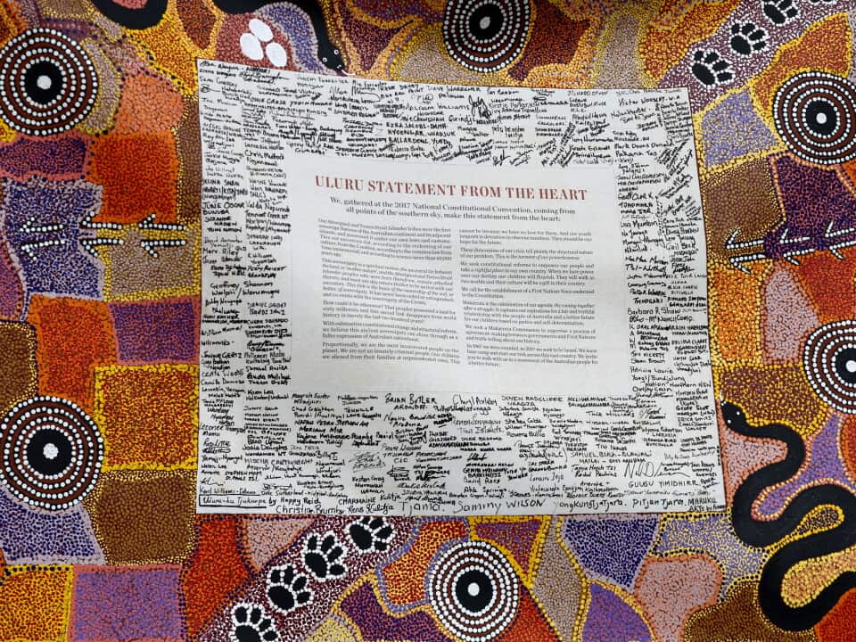 A document surrounded by signatures embedded in a traditional First Nations dot painting