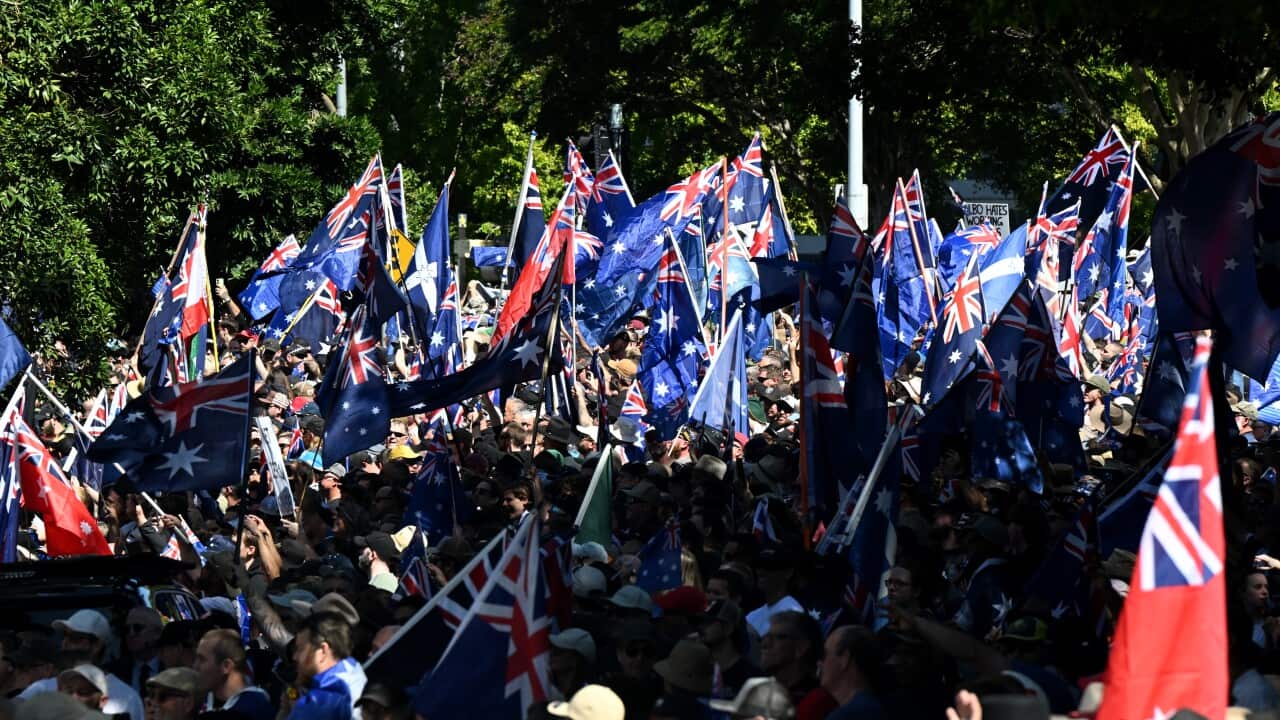 A large crowd, many of whom are waving Australian flags.
