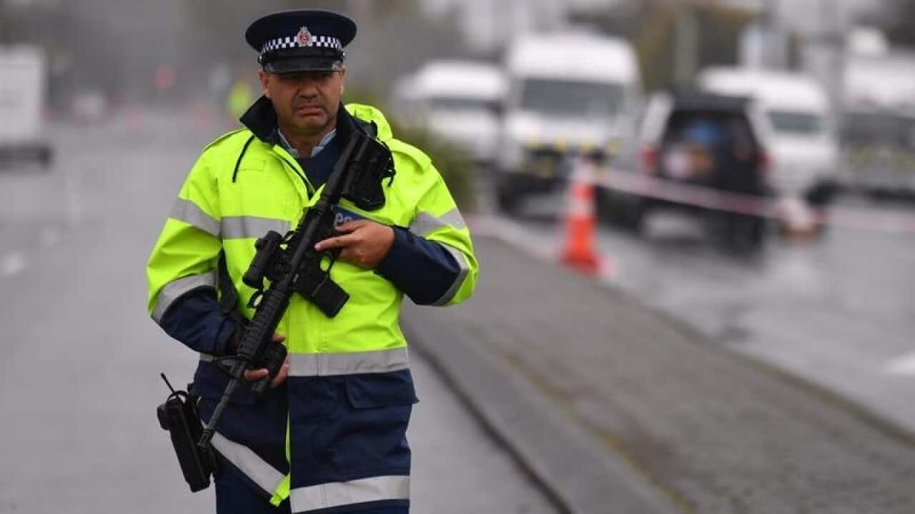 An armed police officer patrols near the Linwood Mosque