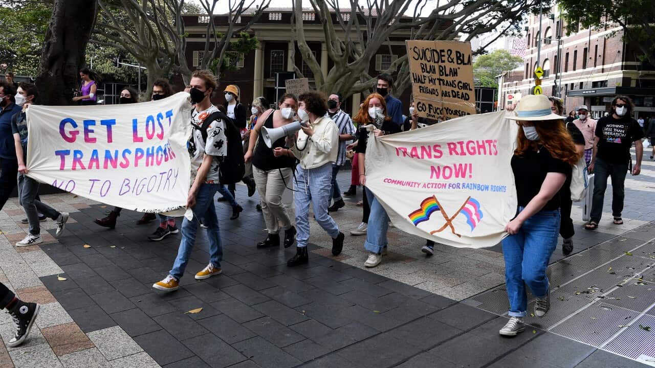 Members of Community Action for Rainbow Rights hold placards as they participate in a protest.