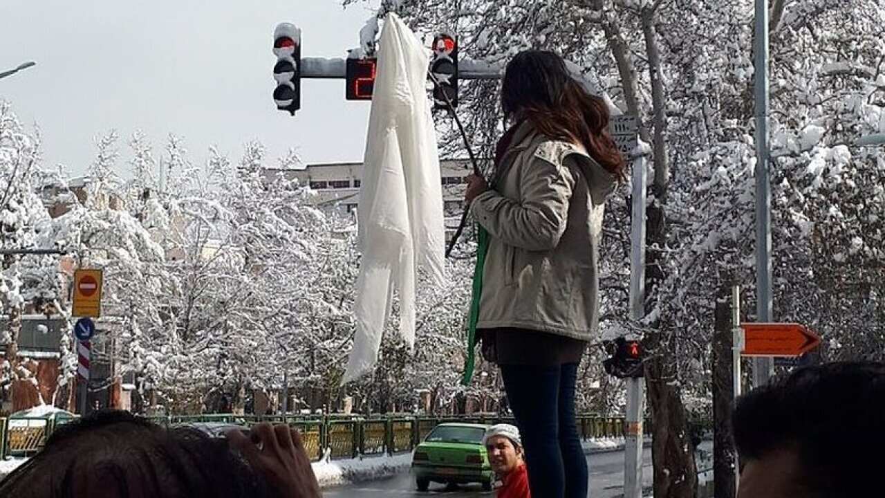 A woman protests Iran's compulsory hijab rule. 