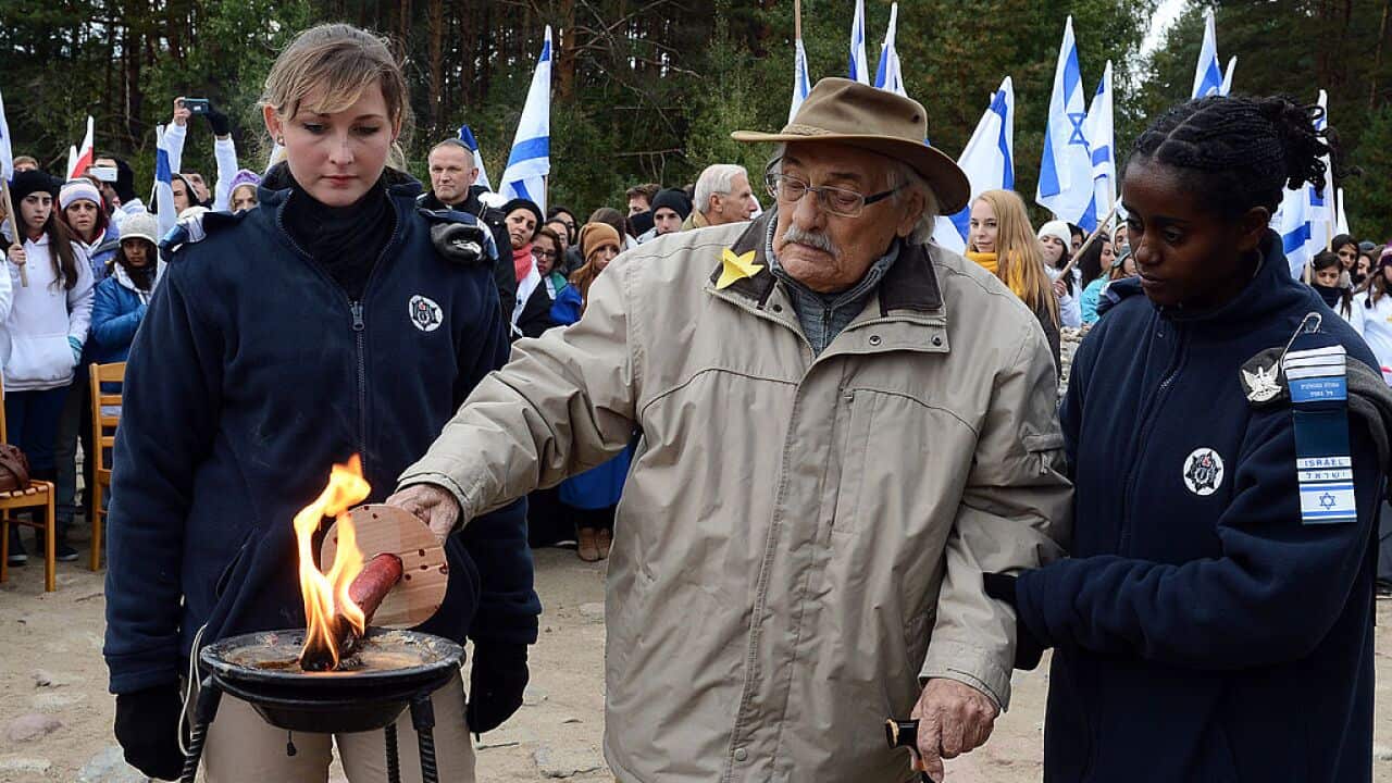 Samuel Willenberg (centre), the only living survivor of an August 1943 prisoner rebellion at Treblinka lights a candle in front of the monument of Treblinka World War II-era Nazi death camp on October 2, 2013 in Treblinka.