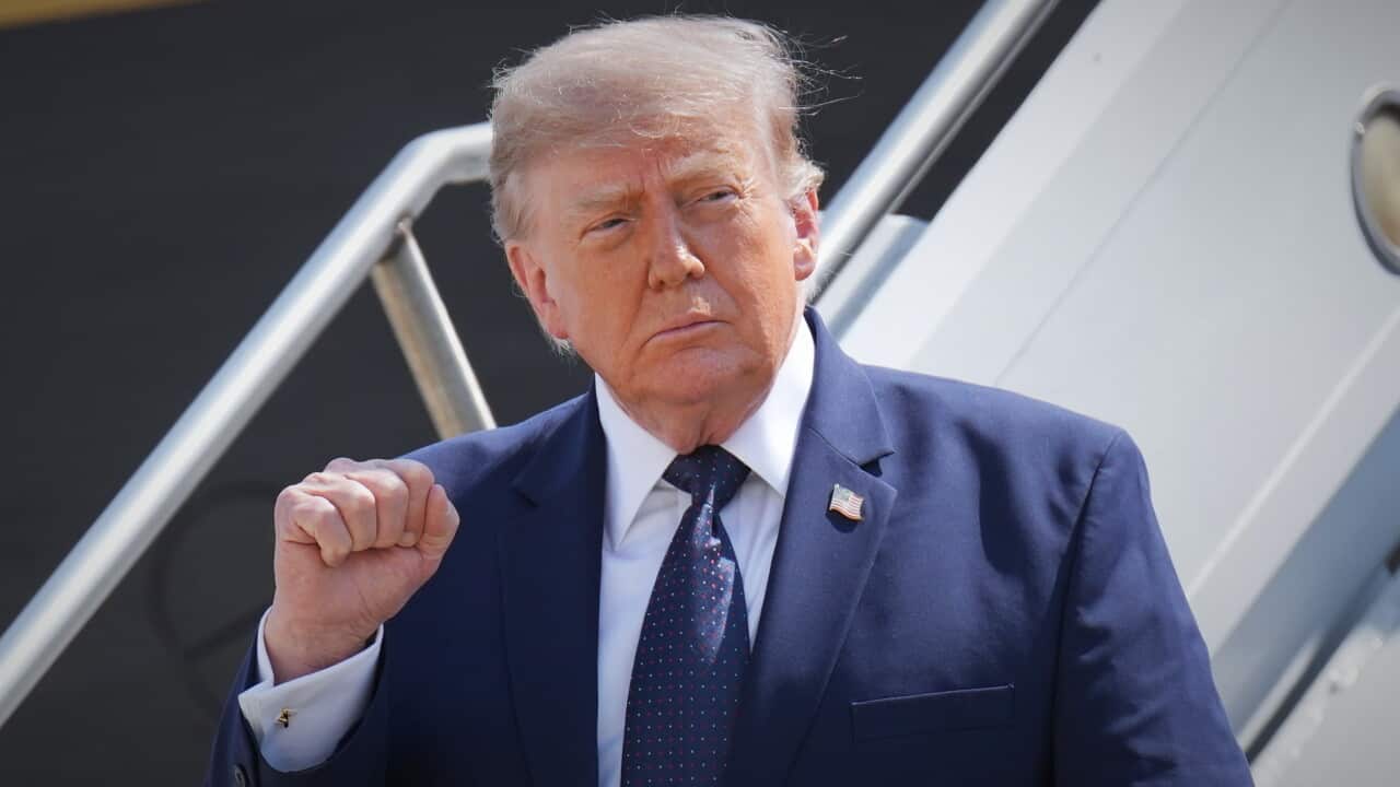 Trump raises a fist as he leaves Air Force One.
