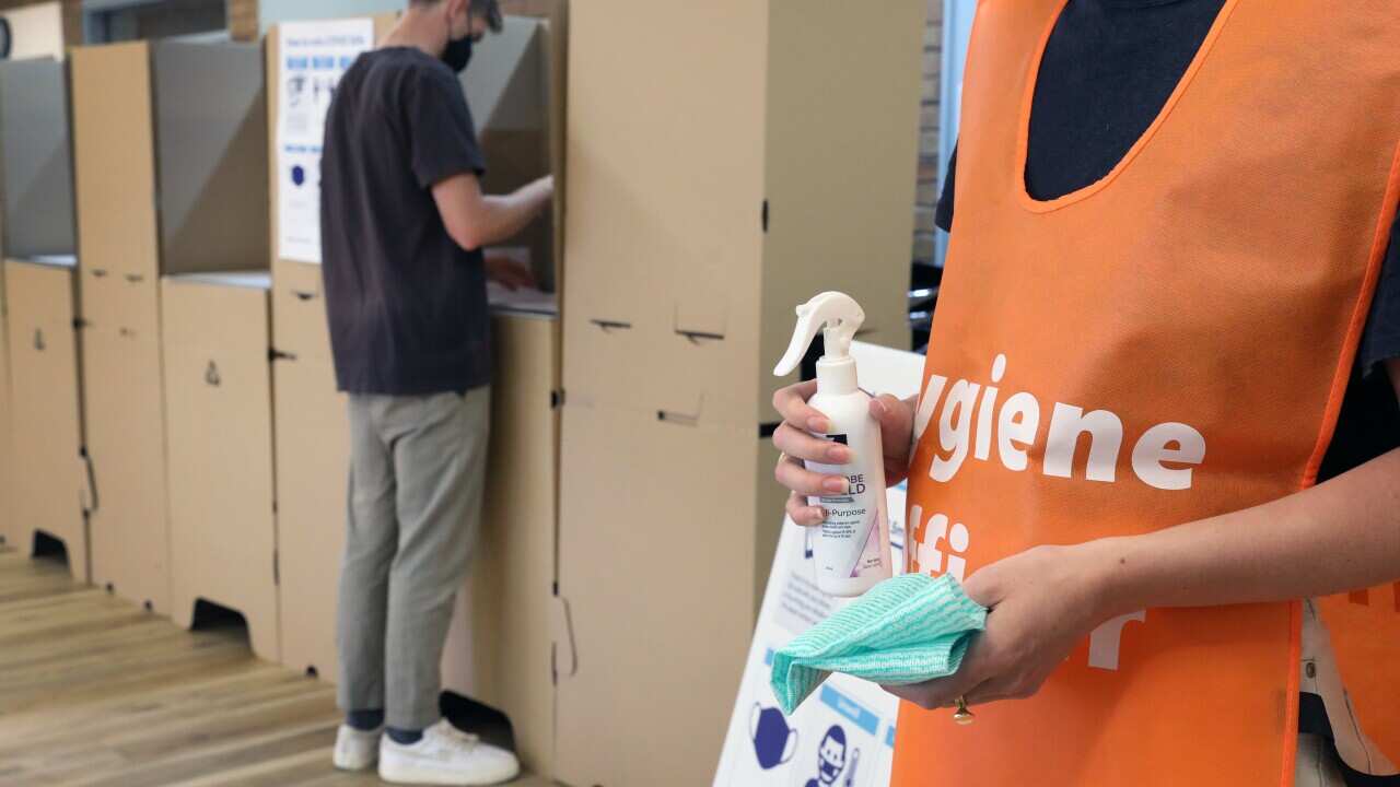 A scene demonstrating the role of hygiene officers at polling locations in South Australia.