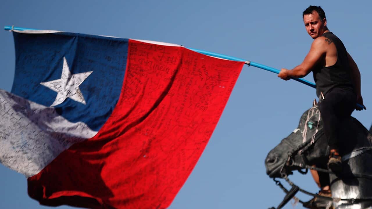 A man waves Chile's national flag during a protest against the government of Chilean President Sebastian Pinera in Santiago.