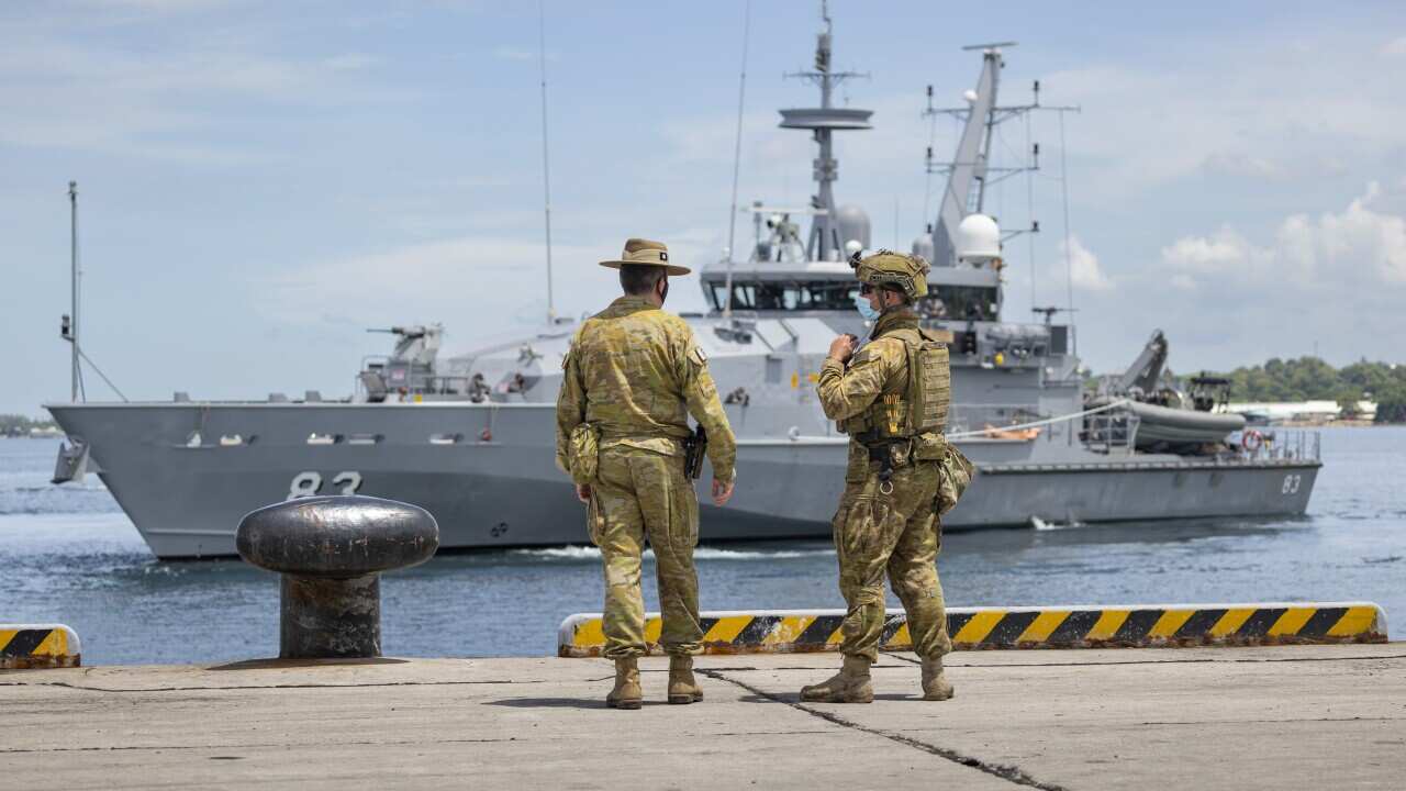 Lieutenant Colonel Steve Frankel (left), and Private Thomas Rixon, watch the Armidale Class Patrol Boat, HMAS Armidale, sail into the Port of Honiara