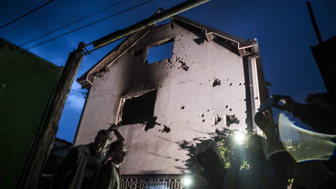 People stand near a destroyed houses following clashes between Macedonian police and an armed group in Kumanovo (Getty Images)