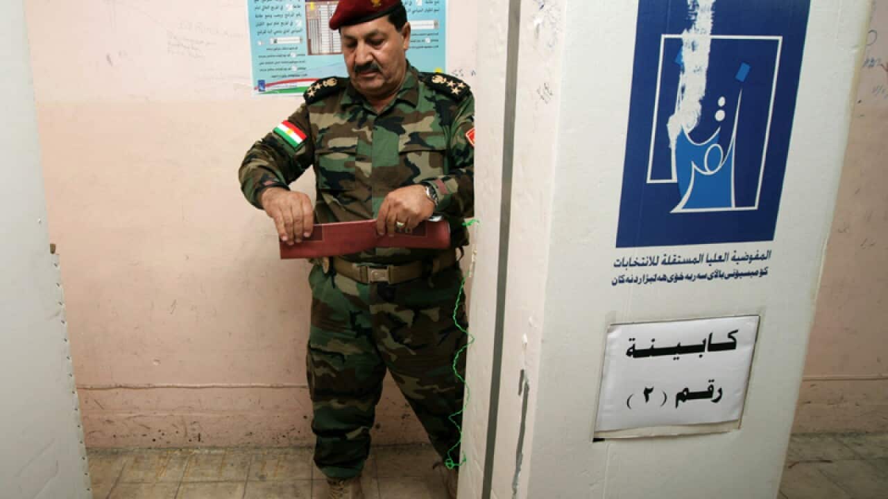 A member of a Kurdish Peshmerga battalion leaves the voting booth