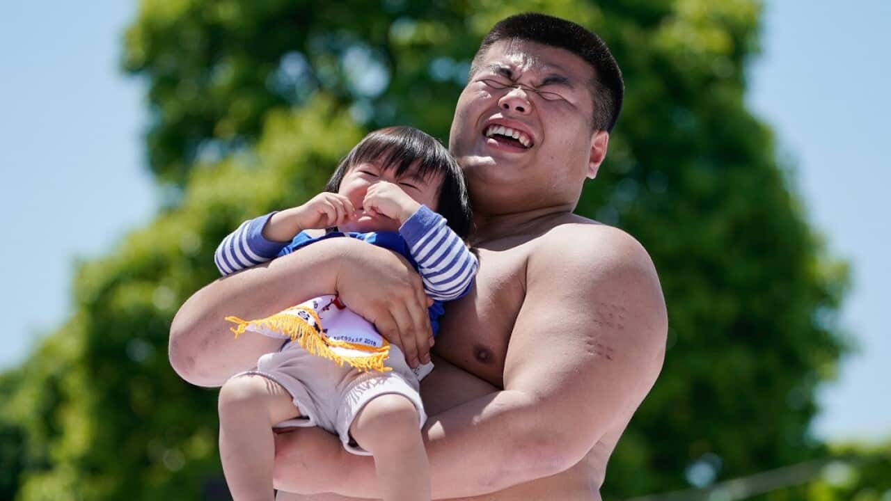 A crying baby is held by an amateur sumo wrestler during Nakizumo, a baby crying contest at Sensoji Temple in Tokyo, Japan.