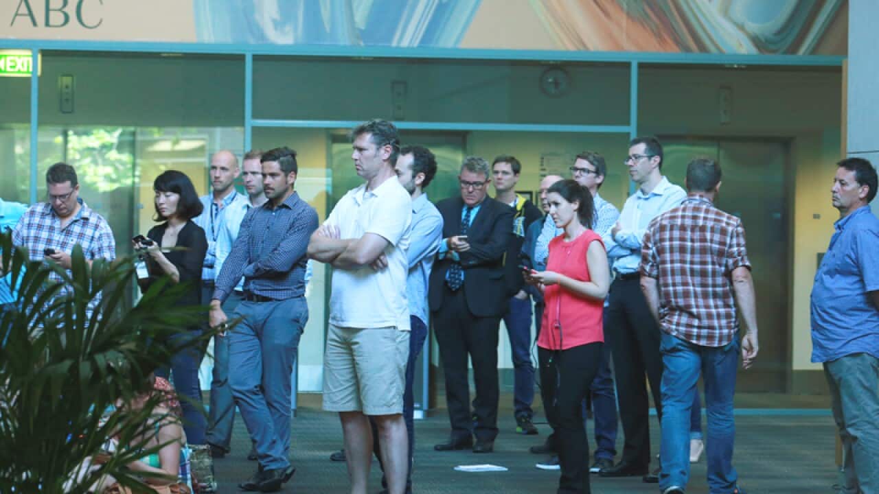 Staff listen to TV broadcast of the ABC's MD Mark Scott