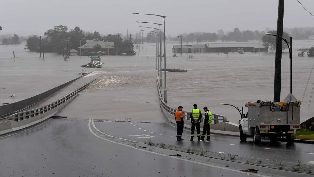 NSW Fire and Rescue look on as the Windsor Bridge is submerged under floodwater from the swollen Hawkesbury River, in Windsor