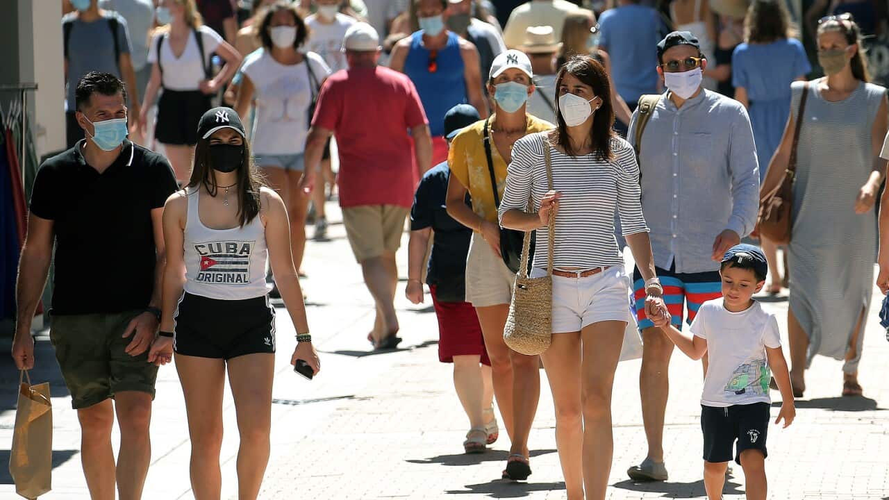 People wearing face masks walk the streets of Saint Jean de Luz, southwestern France.