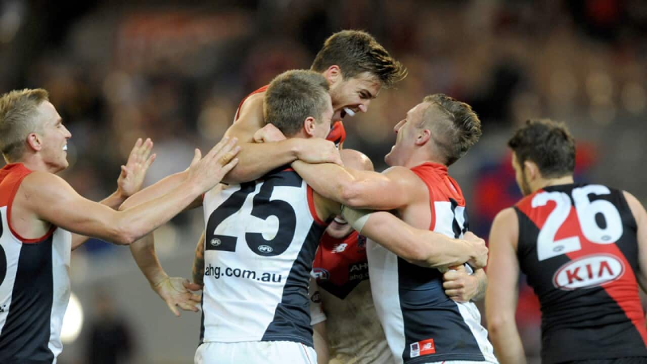Melbourne players celebrate their win against Essendon