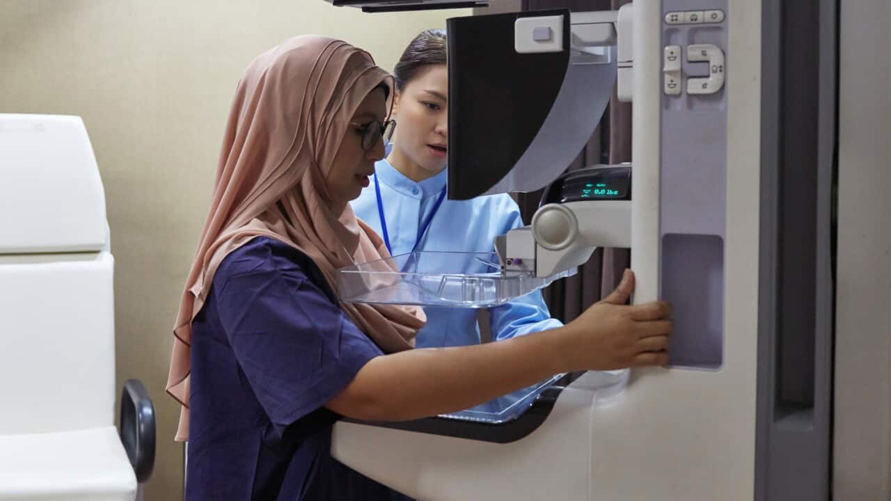 Nurse Assisting Patient During Mammography Exam
