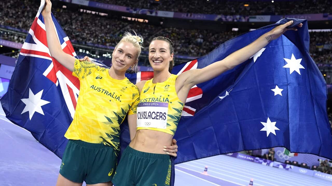 Two smiling women holding an Australian flag