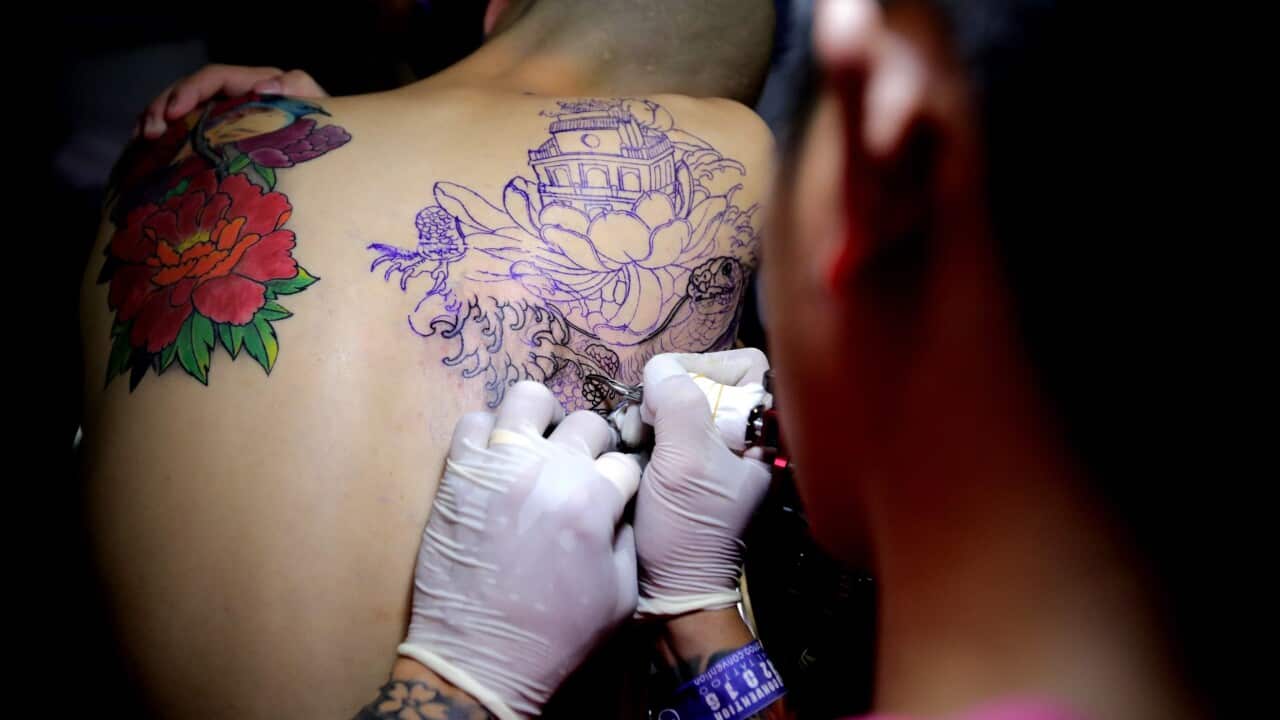 A participant gets a tattoo on his body during the second day of the first ever International Tattoo Convention in Hanoi, Vietnam, 24 June 2016.