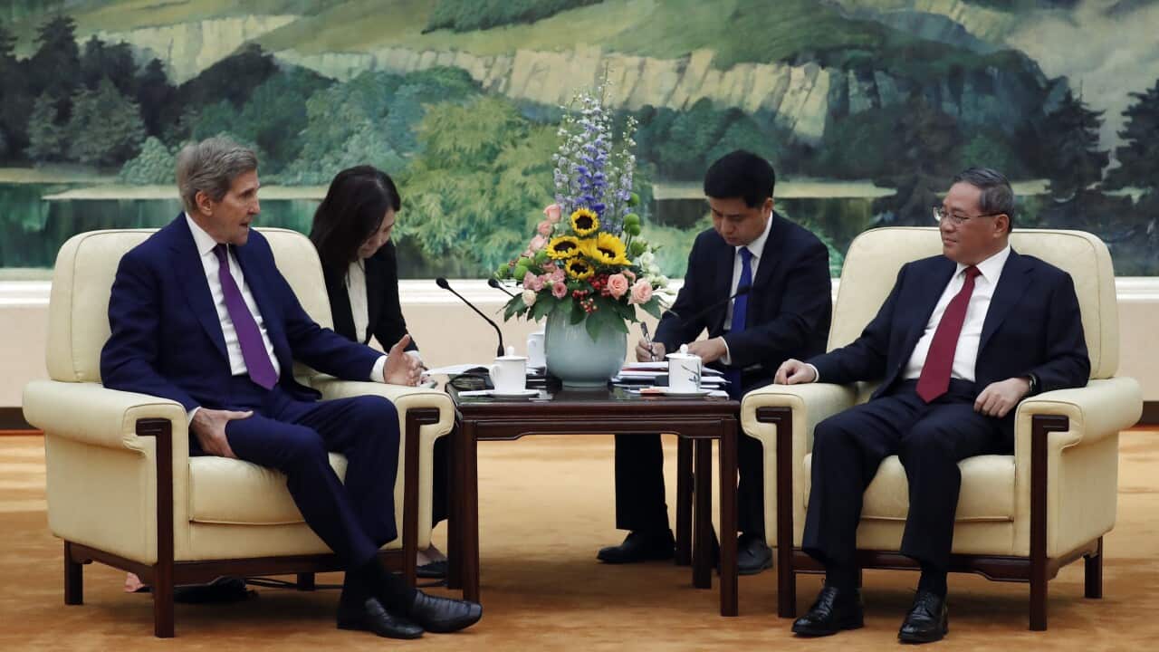 US Special Presidential Envoy for Climate John Kerry (L) and Chinese Premier Li Qiang (R) attend a meeting at the Great Hall of the People in Beijing