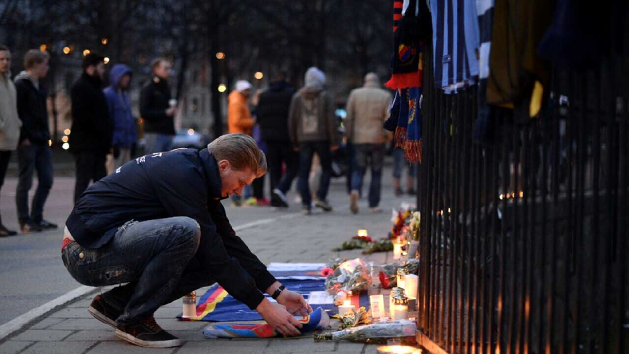 A Swedish football fan pays his respect outside Stockholm's Stadion
