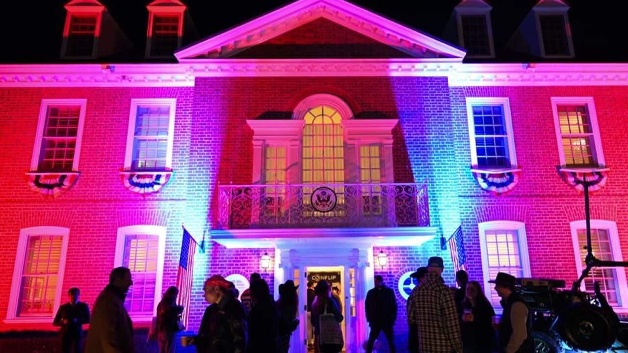 A building with coloured lights projected onto it.