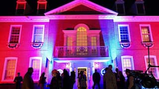 A building with coloured lights projected onto it.