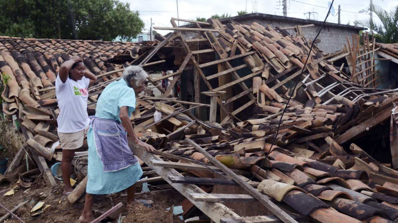 Two women after their home was destroyed by rains and floods, Mexico