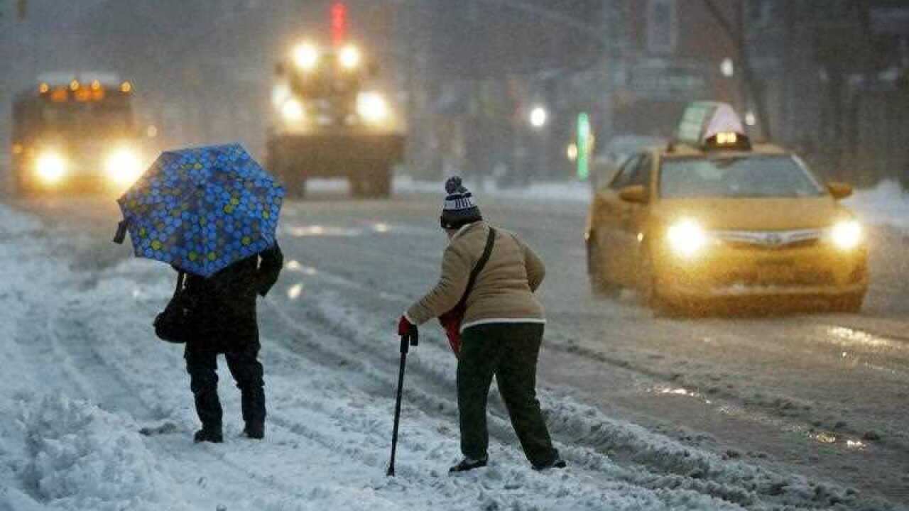 Two women try to cross a street through the snow in New York City, New York, USA, 14 March 2017.