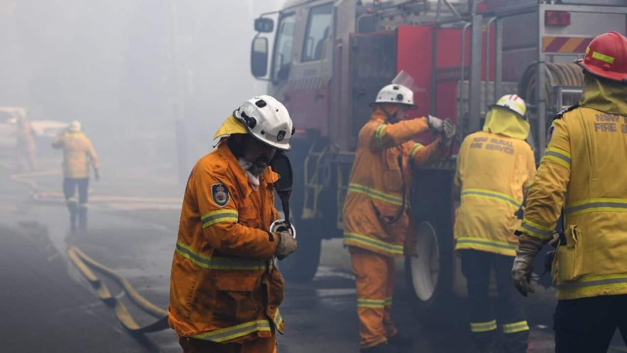 NSW Rural Fire Service personnel conduct property protection as a bushfire burns in Woodford NSW
