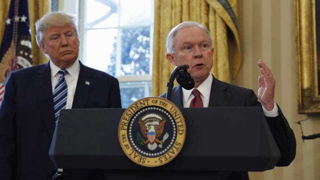 Donald Trump listens as Attorney General Jeff Sessions speaks in the Oval Office of the White House in Washington