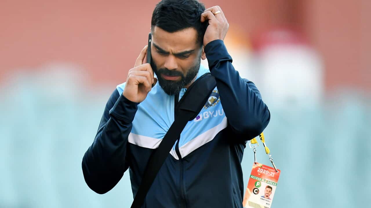 Indian captain Virat Kohli reacts during a telephone call as he leaves the stadium following Australinas victory on day 3 of the first Test Match