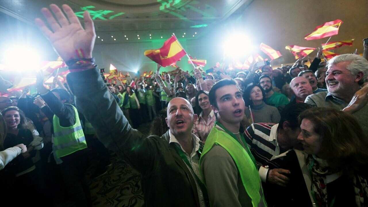 Several supporters of Spanish far-right party Vox celebrate during an election night party in Seville.