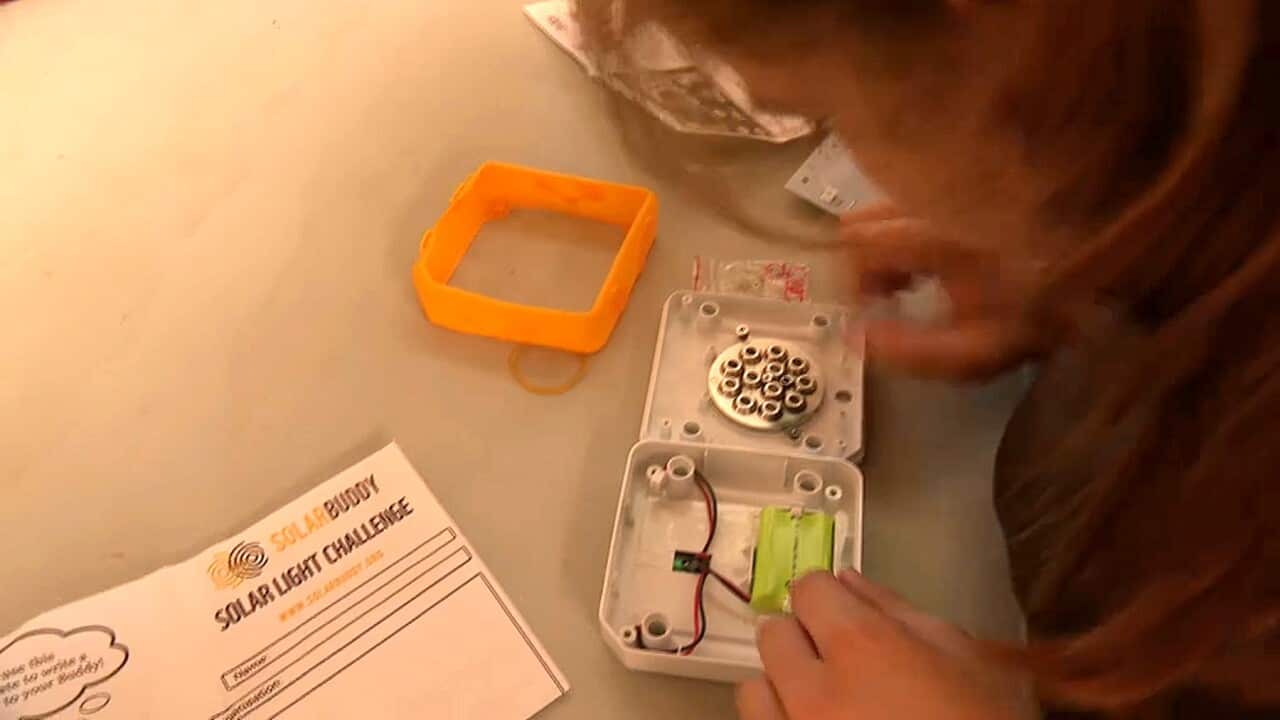 A child working on a solar light for use in PNG