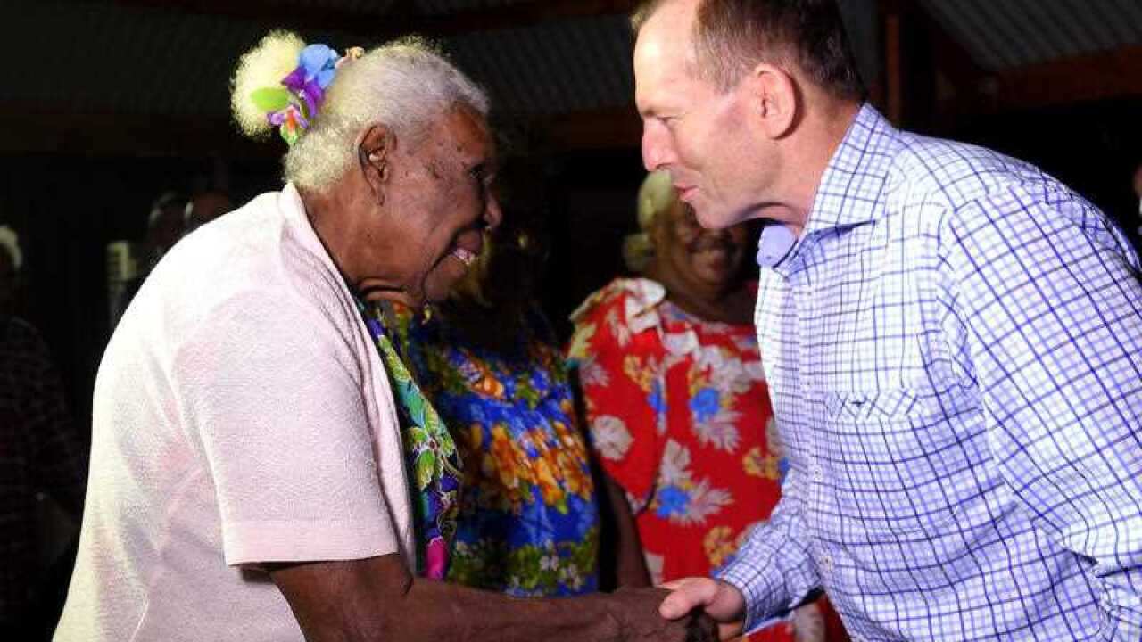 Prime Minister Tony Abbott is greeted by Kaurareg elder Ipiligal Alice Tom as he arrives on Horn Island in the Torres Strait, Sunday, Aug. 23, 2015 (AAP)