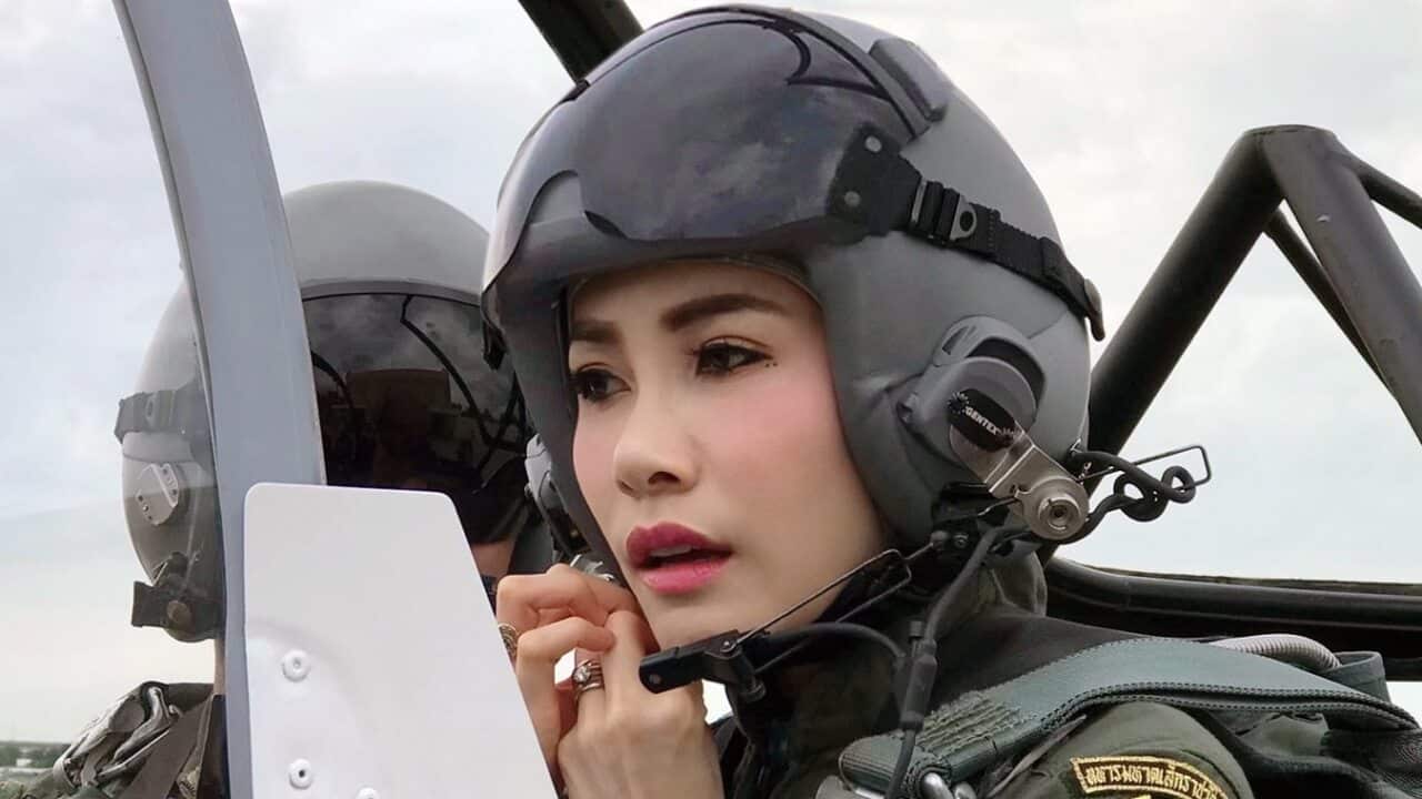 Thai royal noble consort Sineenat Wongvajirapakdi adjusting her pilot helmet in a military aircraft during training in Thailand.